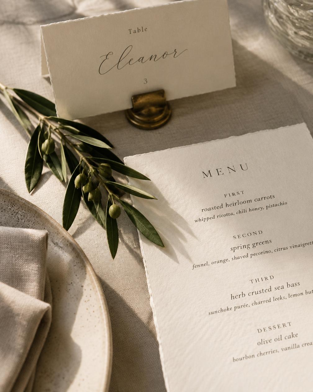 Hand-lettered place card and menu on textured ivory paper